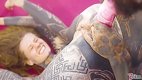 A gorgeous tattooed lady is having her ass drilled by a big cock