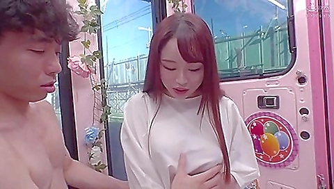 Asian girl shows her face on a mirror with big boobs